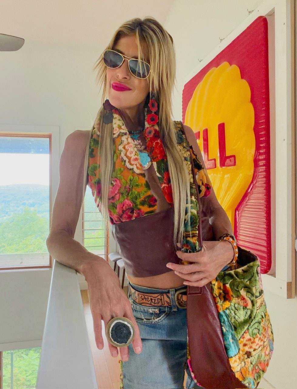 Michelle DaRin styled in floral vest and velvet bag by Shell painting